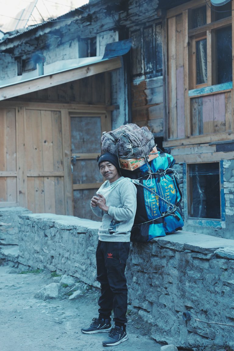 Young porter in a mountain village lane