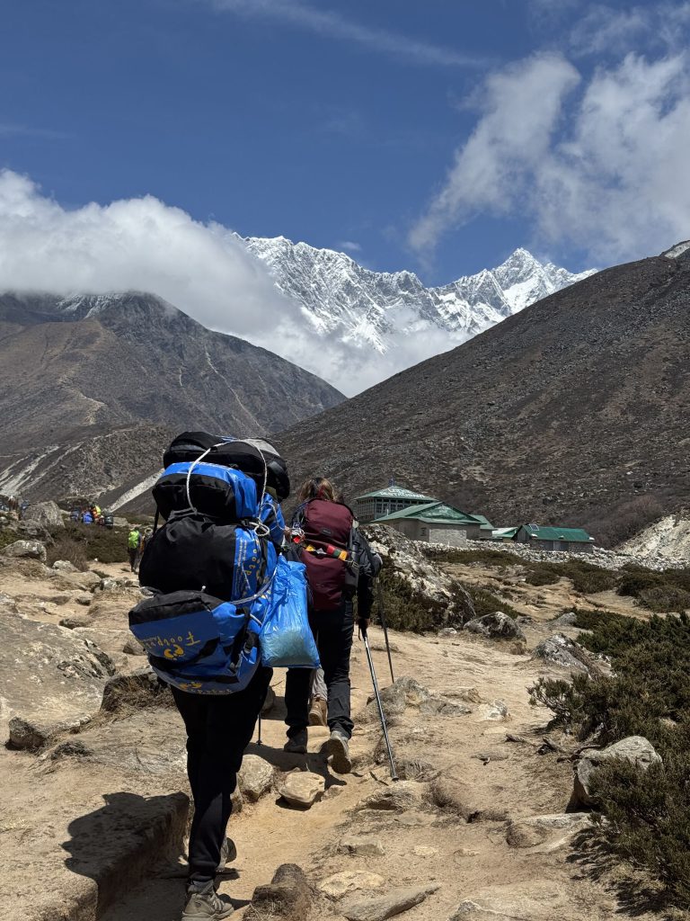 Porters on a cliffside trail below Everest