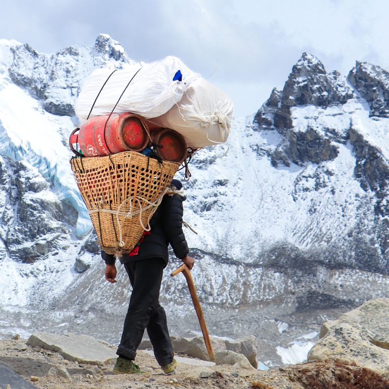 Porter carrying a load through the Himalaya